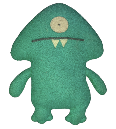 A green felt one-eyed puppet with two small white fangs, facing forward